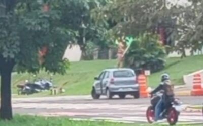Mulher em protesto ousado clama por justiça fraternal sobre carro em Campo Grande, MS, gerando comoção.